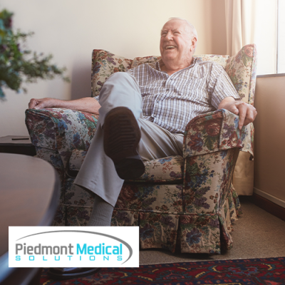 Smiling elderly man sitting comfortably in floral armchair 