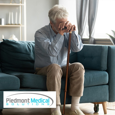 Older gentlemen resting his head on his cane while sitting on the couch