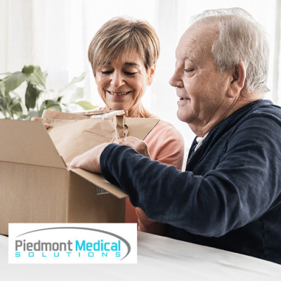 Older man and woman opening a cardboard box together